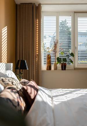 des shutters et des plantes pour bloquer les regards indiscrets dans la chambre à coucher